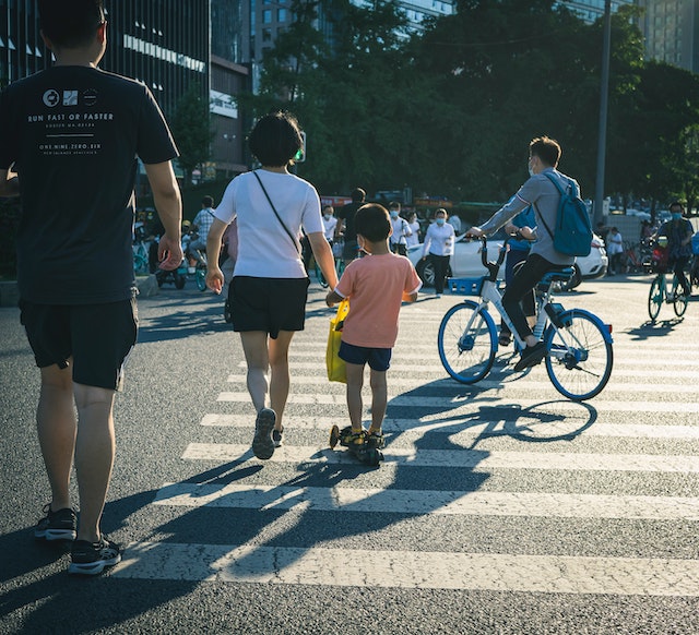 Man walking bike on busy city street