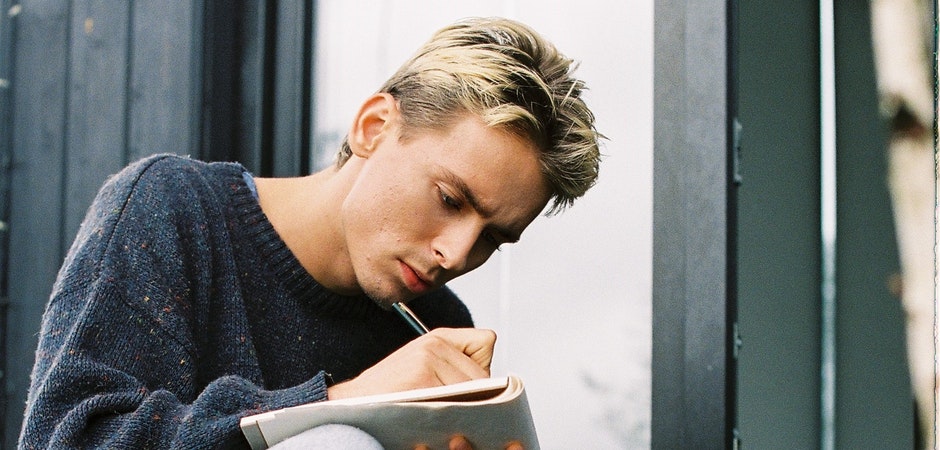 man sketching in notebook